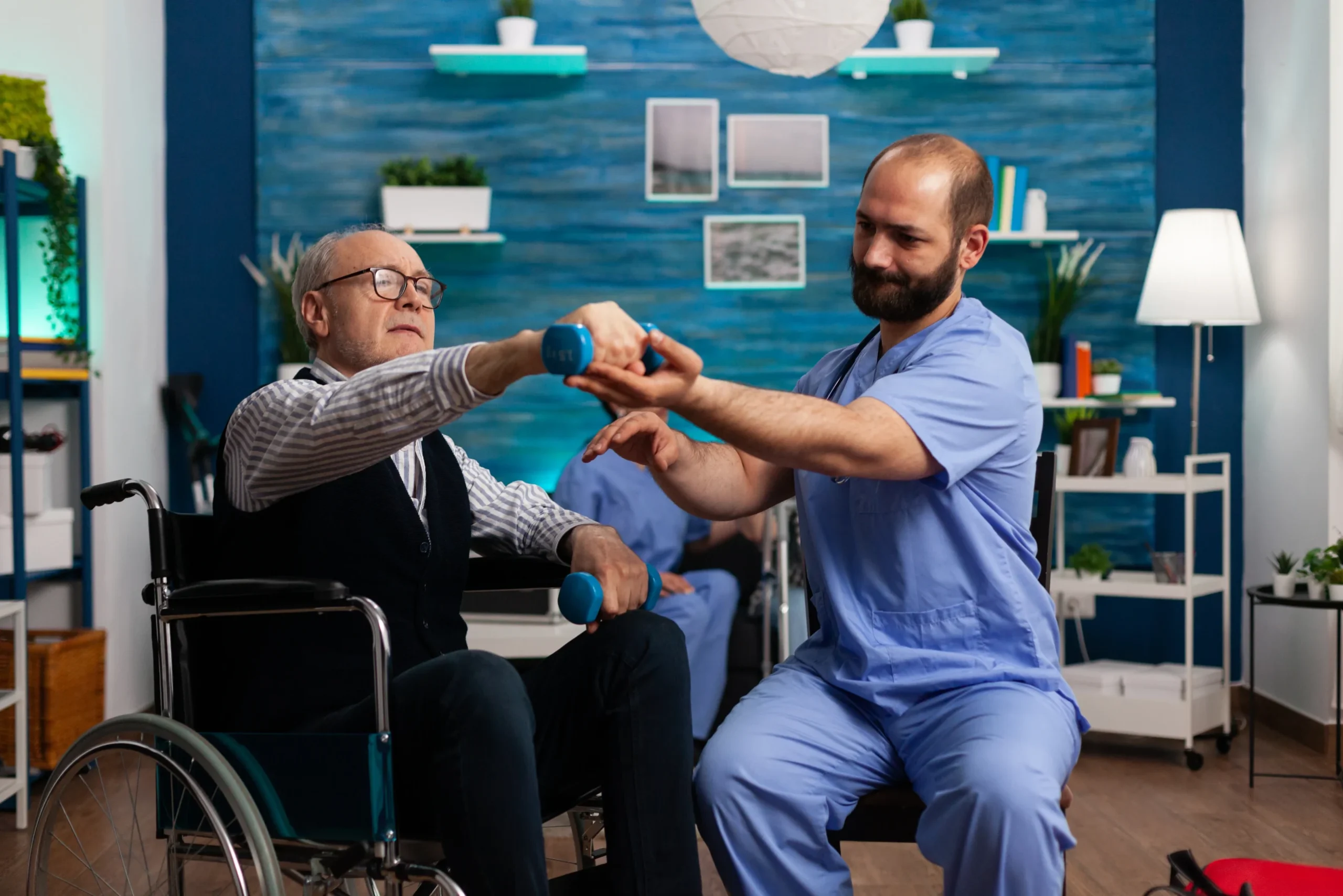 practitioner-man-doctor-helping-retiree-senior-male-wheelchair-physiotherapy-strength-exercise